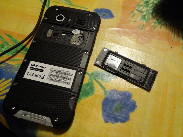 La trappe de la carte avec les emplacements SIM + carte SD. Remarquez le joint.